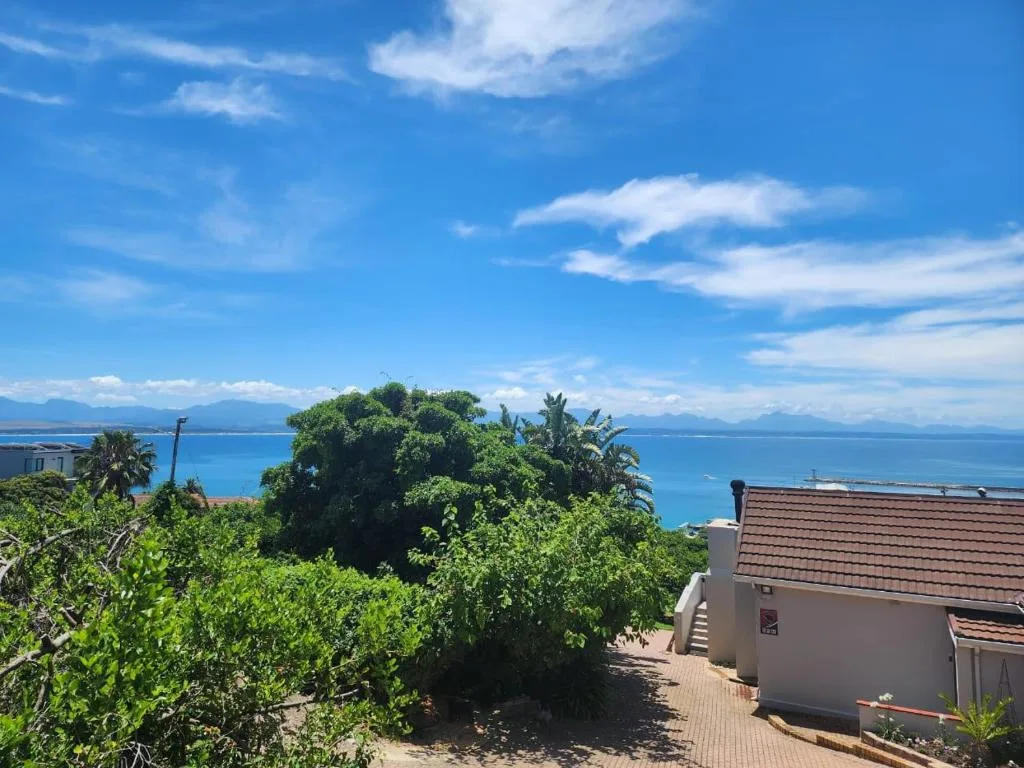 Stunning coastal view of turquoise ocean and mountains from property garden