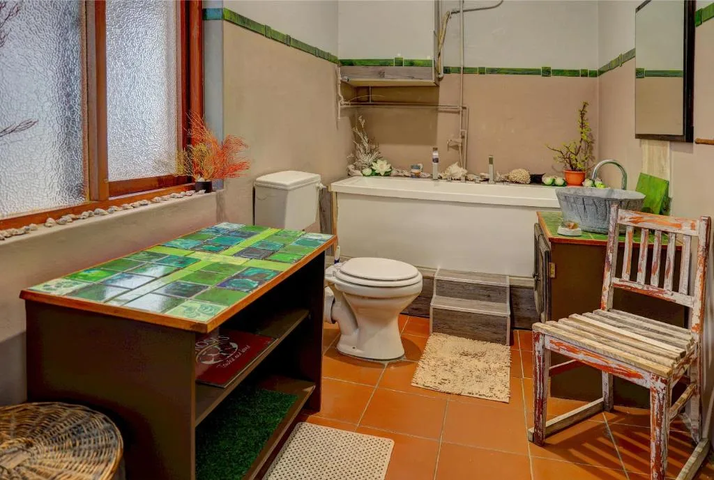 Spacious bathroom with colorful tile vanity, soaking tub, and rustic chair decor
