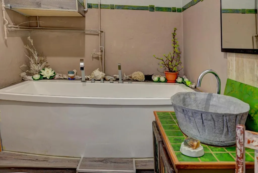 Spacious bathroom with soaking tub and decorative plants displayed on ledge