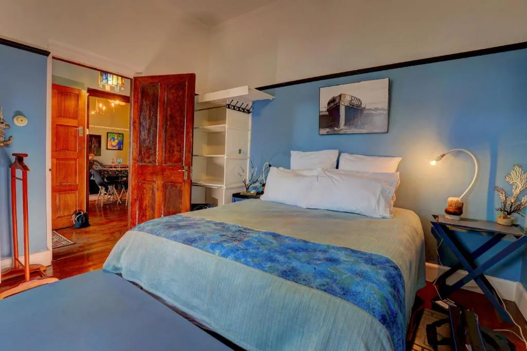 Spacious bedroom with queen bed, blue accent walls, and nautical decor
