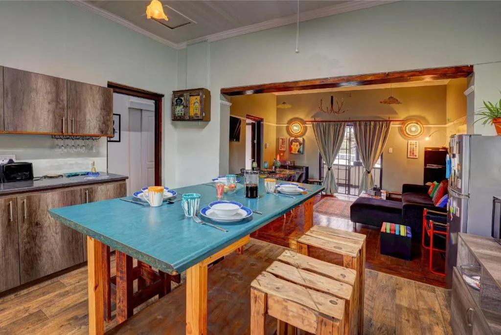 Open-plan kitchen and dining area with turquoise island table and place settings
