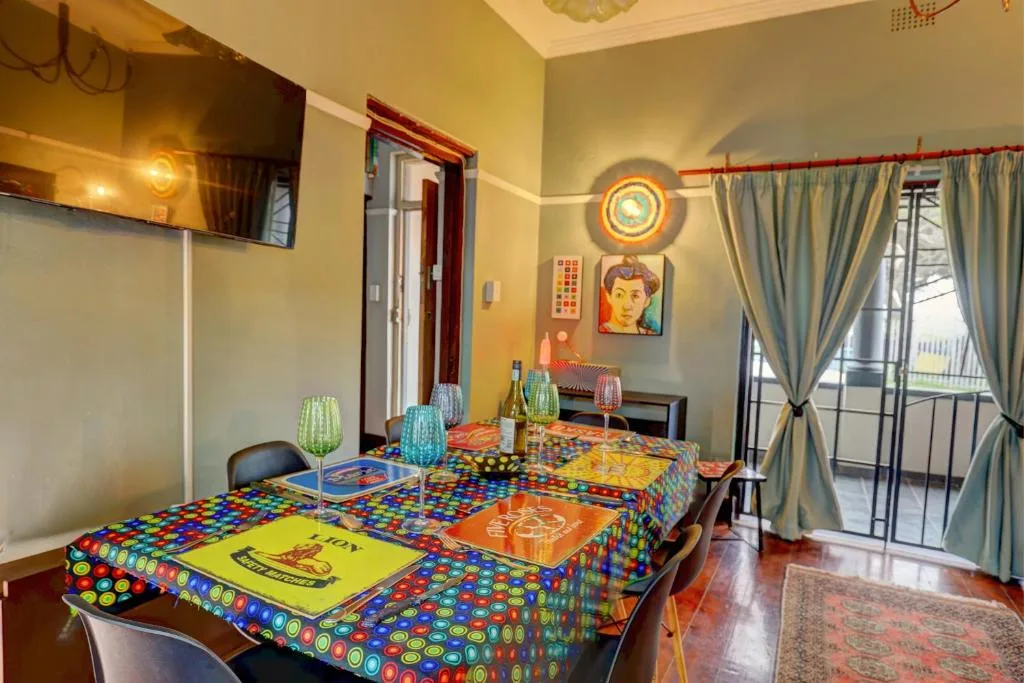 Colorful dining area with patterned tablecloth and outdoor deck access