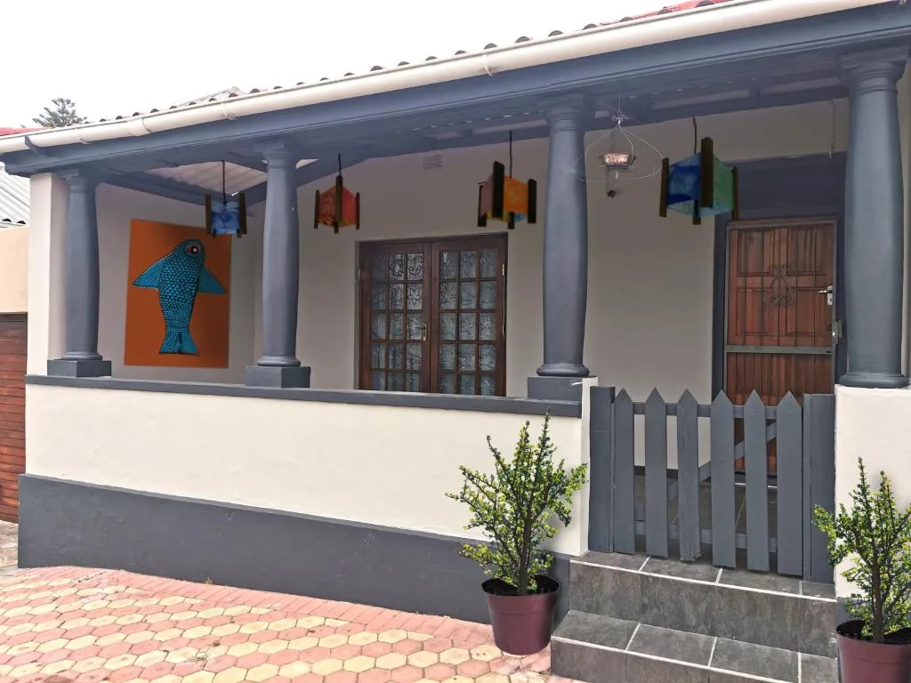 Modern cottage facade with colorful artwork and wooden doors entrance
