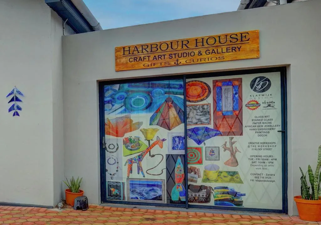 Art studio storefront with colorful window display and wooden signage
