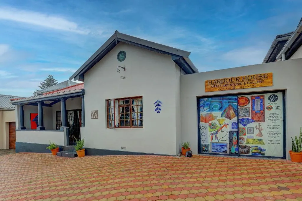 White cottage with blue trim and brick patio entrance, Garden Route