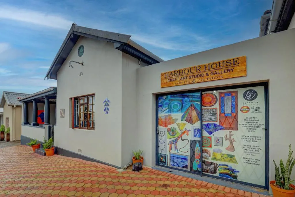 White cottage with art studio gallery storefront and brick courtyard entrance