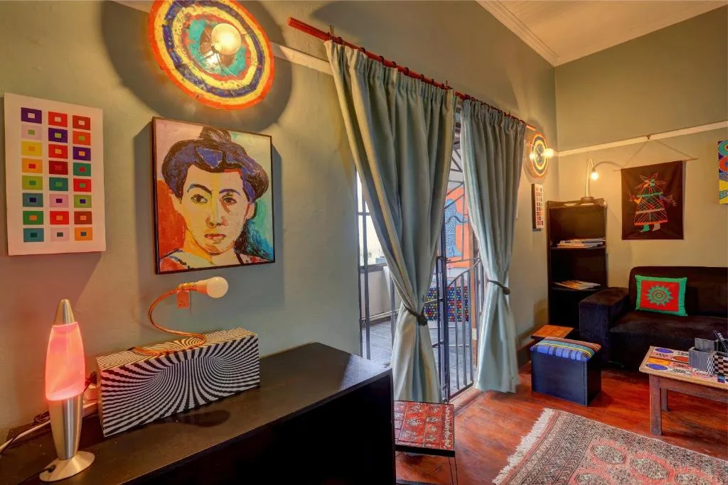 Colorful lounge with eclectic art, neon lighting, and access to deck