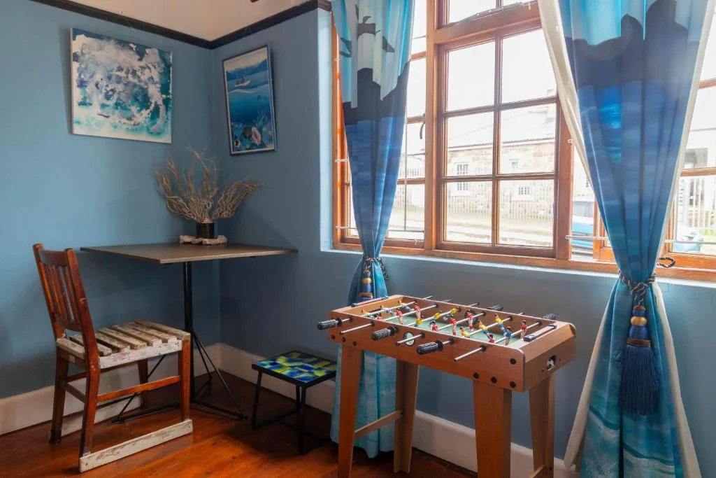 Blue room with foosball table, desk, and coastal artwork displayed