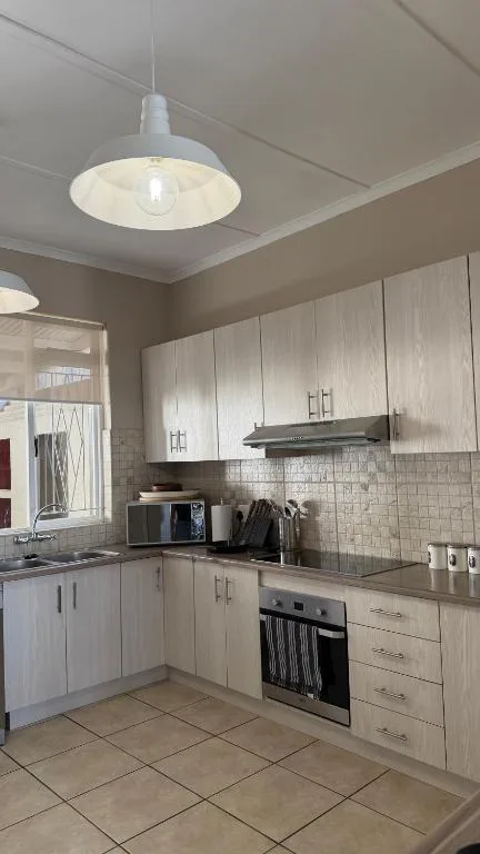 Modern kitchen with white cabinetry, stainless steel appliances, and pendant lighting
