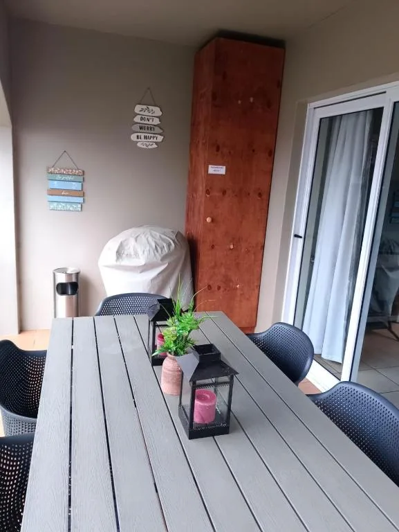 Outdoor patio with wooden table, chairs, and decorative potted plants