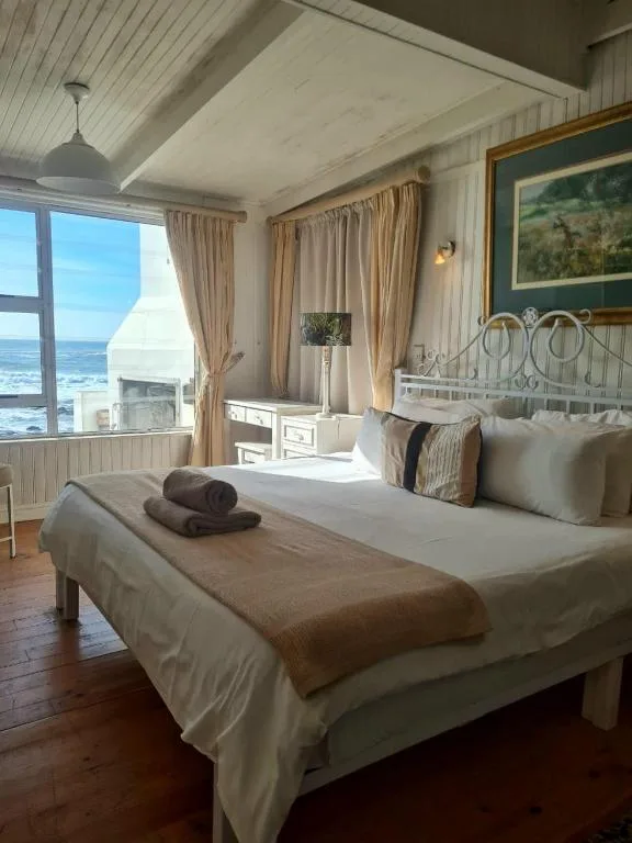 Coastal bedroom with ocean view, white metal bed frame, and natural light