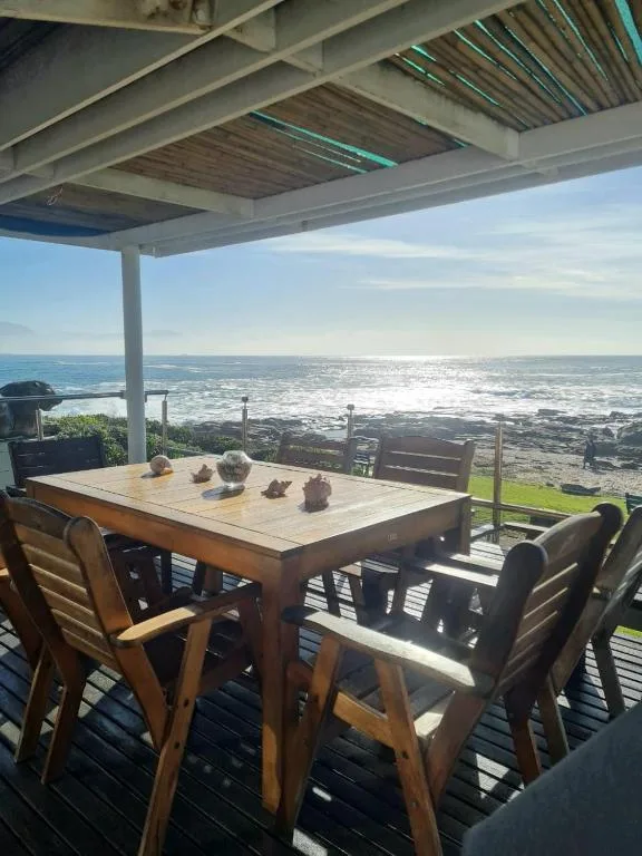 Wooden dining table with ocean view from covered beachfront patio
