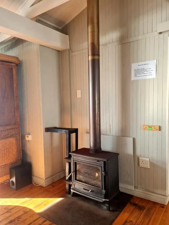 Wood-burning stove with copper chimney in modern interior space