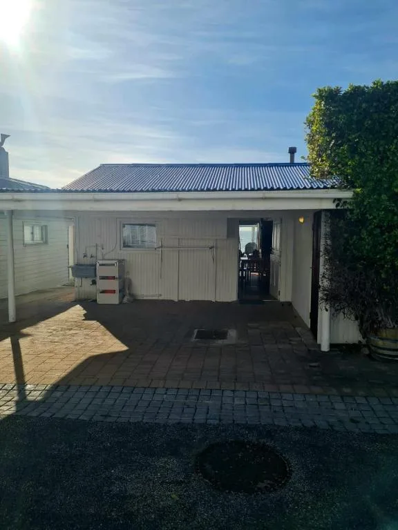 Modern white cottage with metal roof and covered porch entrance
