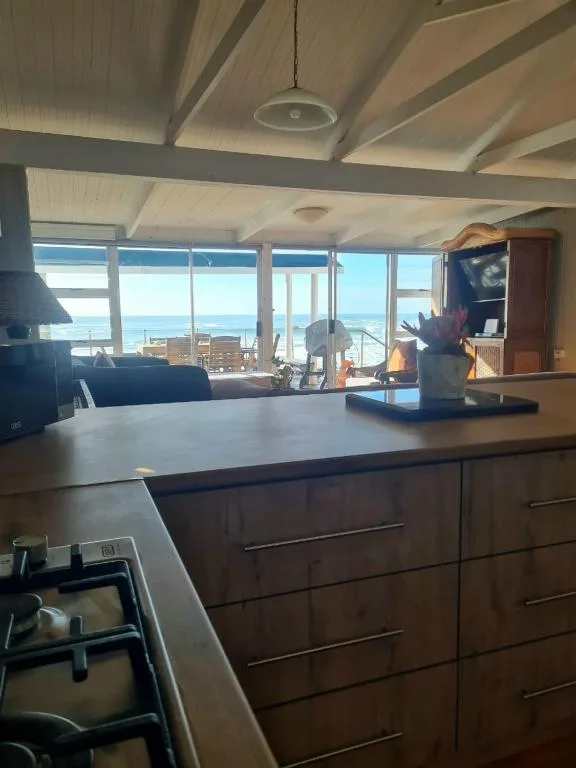 Modern kitchen with ocean view through large windows and coastal scenery