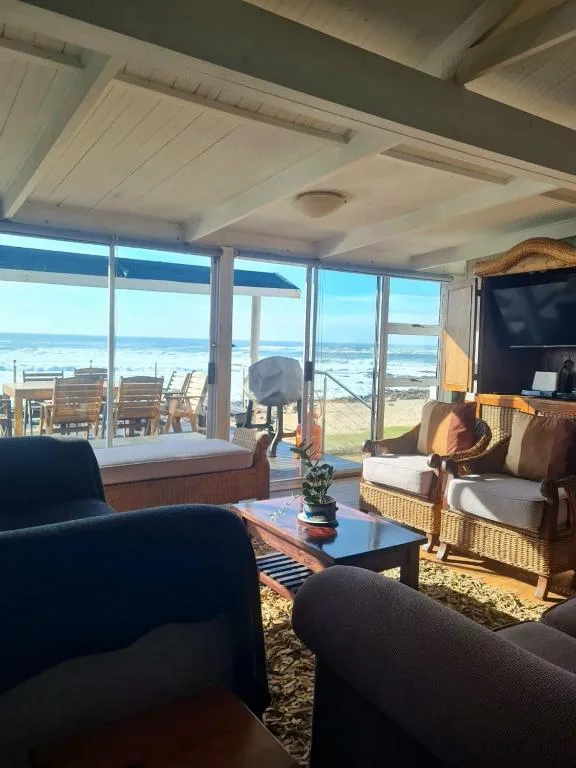 Spacious living room with ocean views through large windows and comfortable seating
