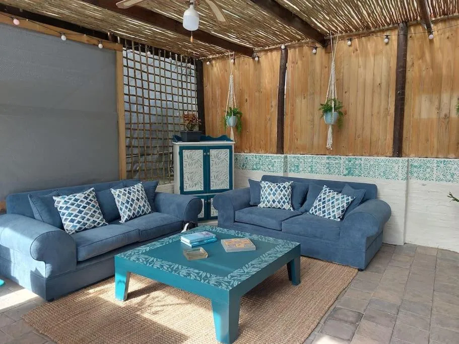 Covered outdoor seating area with blue sofas and turquoise coffee table