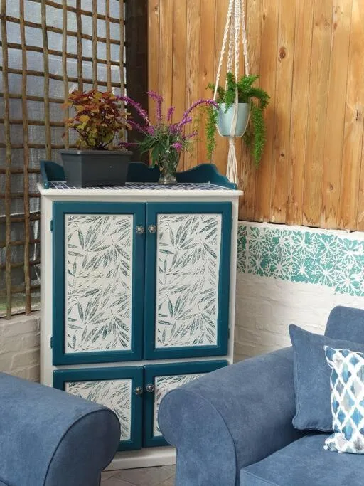 Outdoor seating area with blue upholstered chairs and decorative cabinet