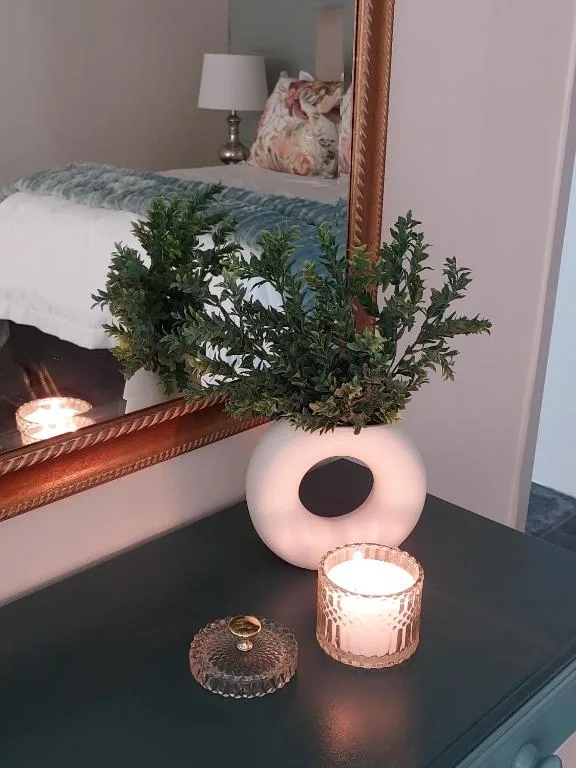 Bedside table decor with potted greenery and candles