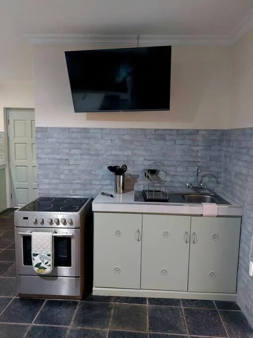 Modern kitchenette with stainless steel range cooker and white cabinetry
