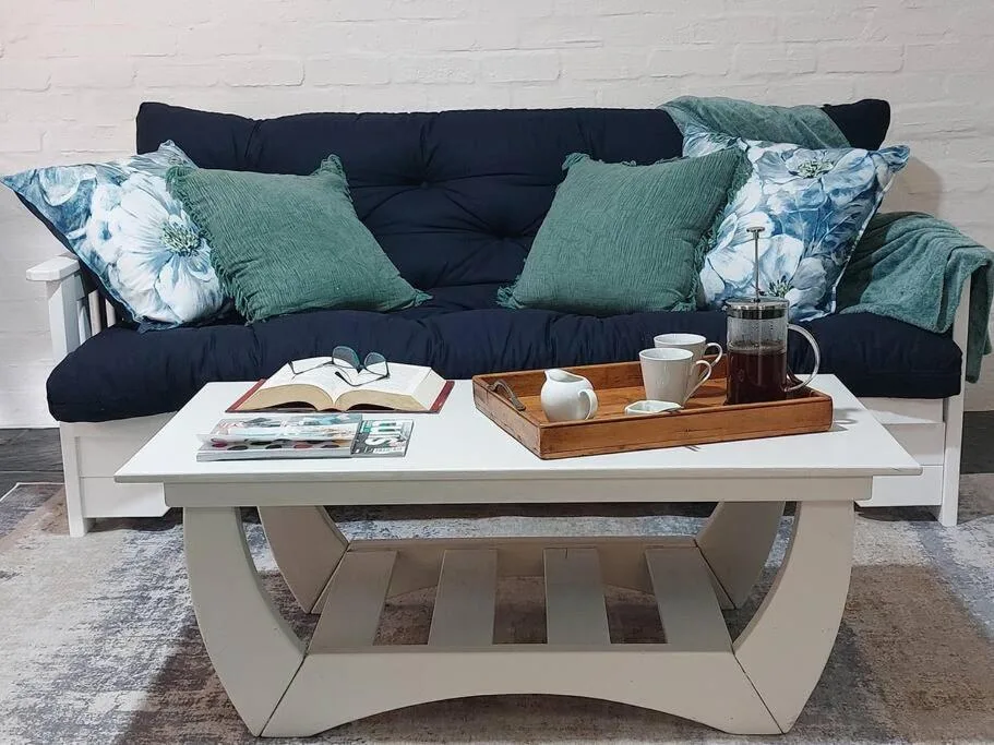 Cozy lounge with navy sofa, green cushions, and white coffee table