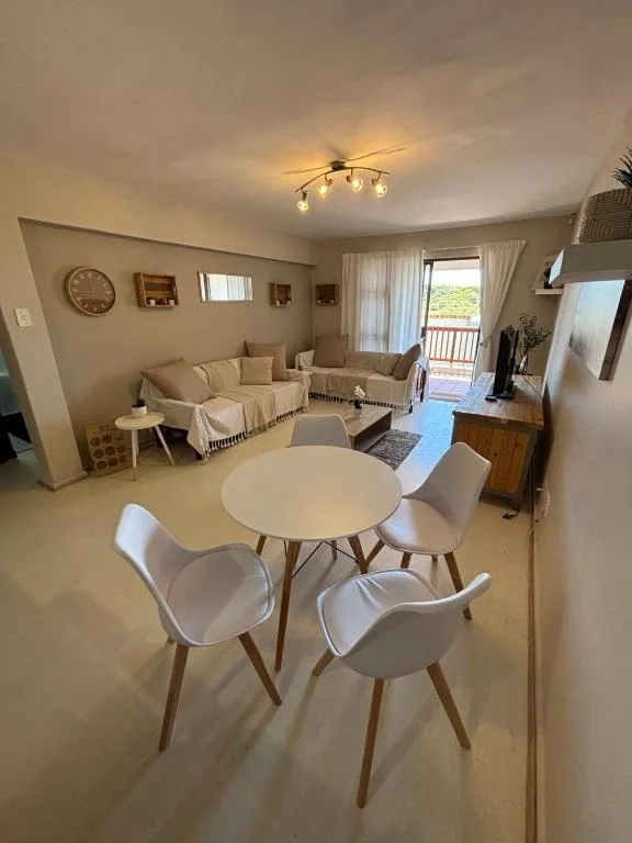 Open-plan living and dining area with modern furnishings and deck access