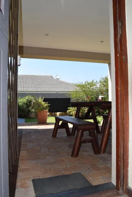Outdoor patio area with wooden table and chairs overlooking garden
