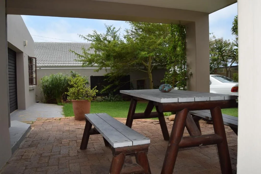 Outdoor patio with ping pong table and garden seating area under cover