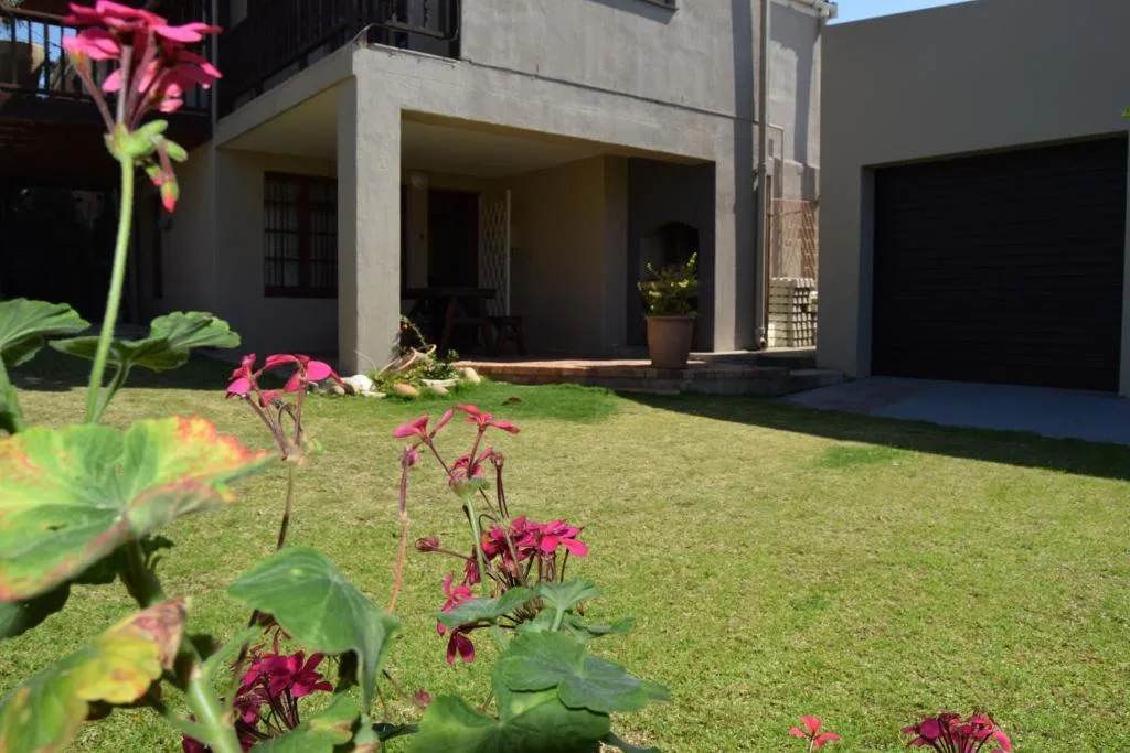 Modern home facade with manicured garden and pink flowering plants