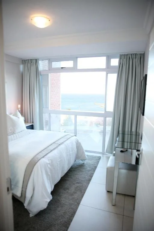 Bright bedroom with ocean and bay views through large windows