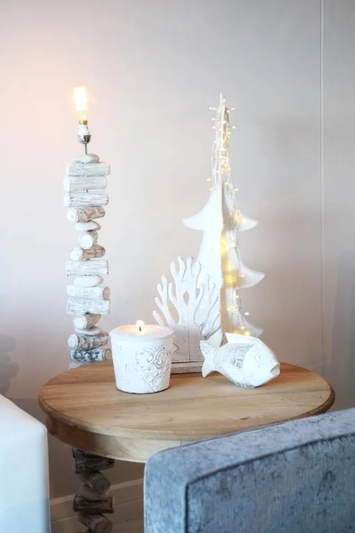 Wooden table with decorative white coastal ornaments and candles
