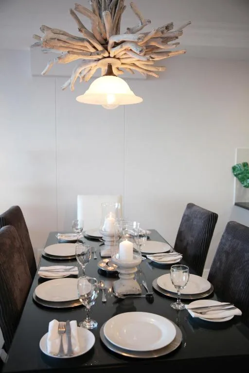 Elegant dining table set for four with driftwood ceiling fixture
