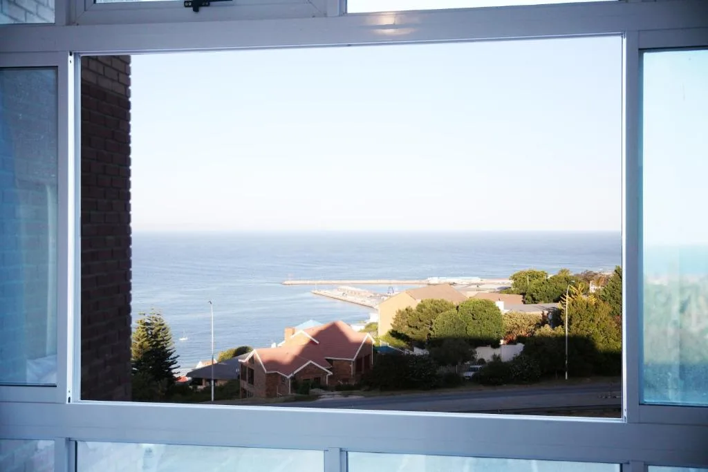 Scenic coastal view of Mossel Bay with ocean, beach, and neighboring homes