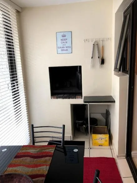 Compact bedroom lounge area with wall-mounted TV and small desk