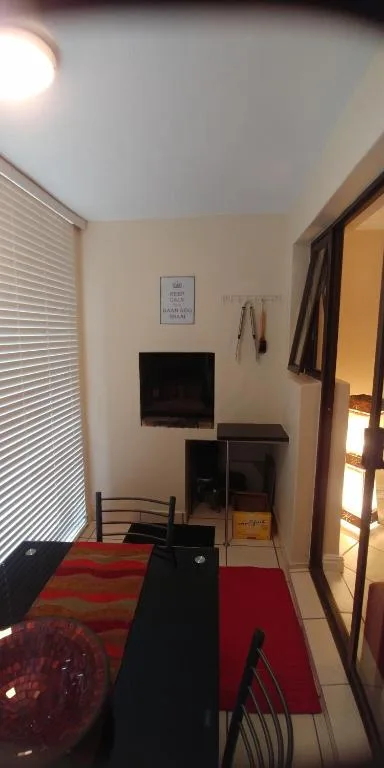 Compact living room with wall-mounted TV and red area rug