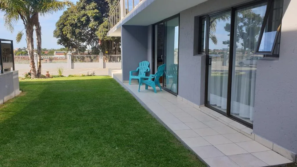 Modern patio with turquoise chairs overlooking manicured garden and lagoon views