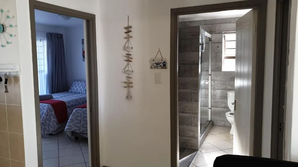 Interior hallway showing bedroom and bathroom doorways with decor