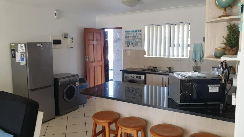 Modern kitchen with stove, oven, fridge, and black countertops