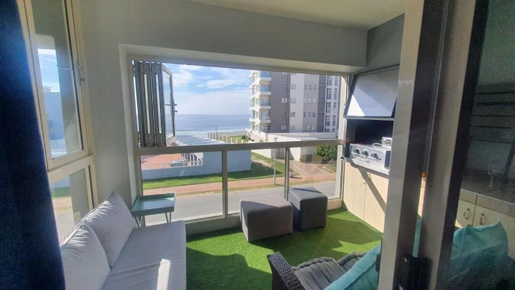 Balcony with artificial turf, seating, and ocean views of Mossel Bay coastline