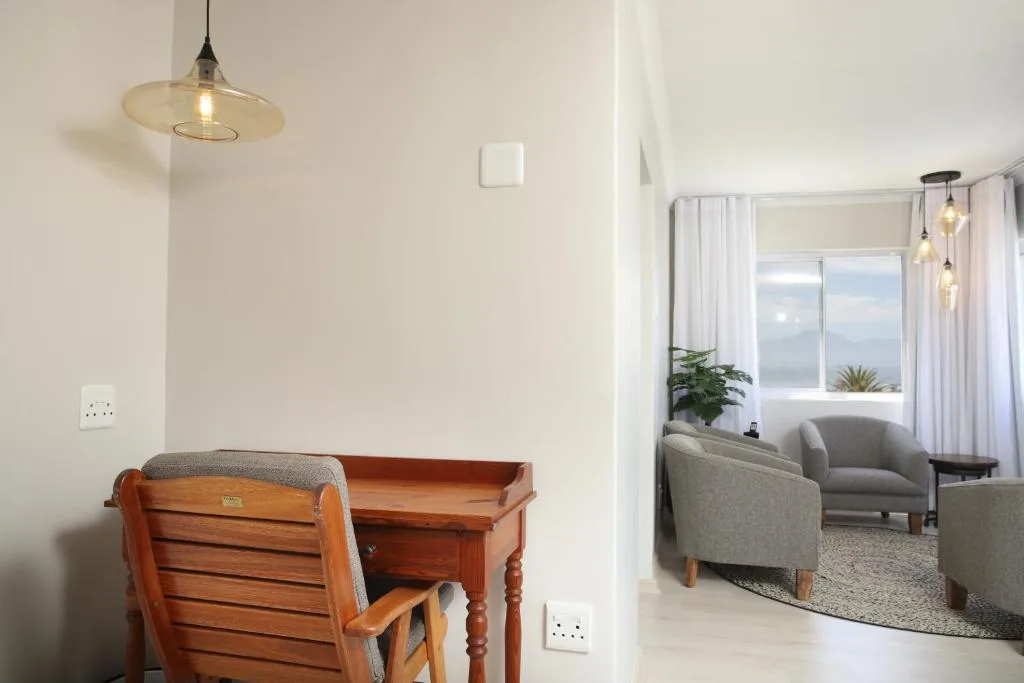 Modern pendant lighting and wooden desk in bright apartment interior