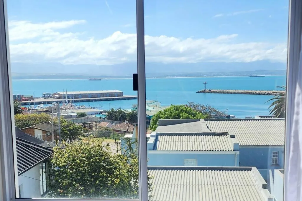 Turquoise bay and harbor view through large windows overlooking coastal town