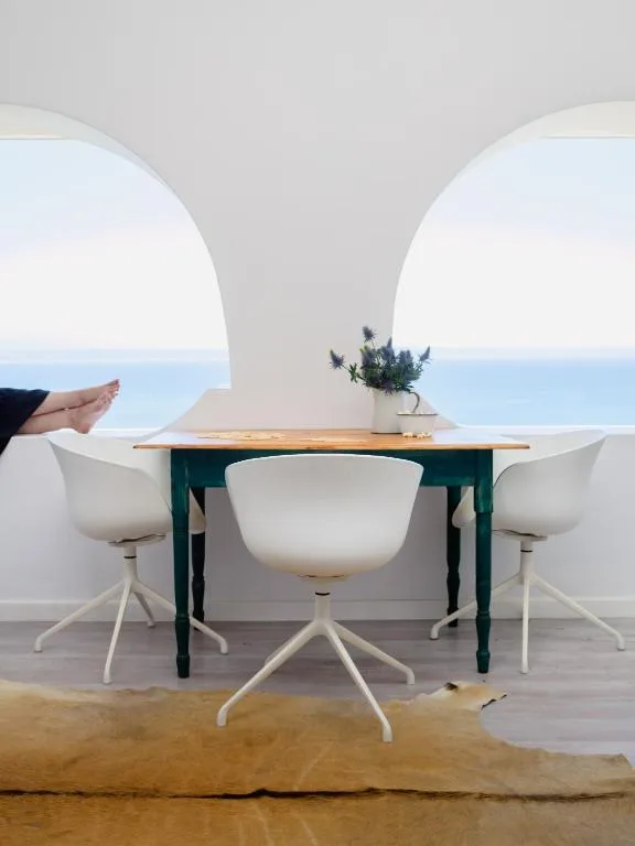 Dining table with ocean view through curved architectural openings