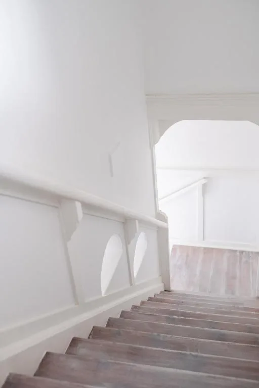 Modern white staircase leading up to bright entrance with ocean views