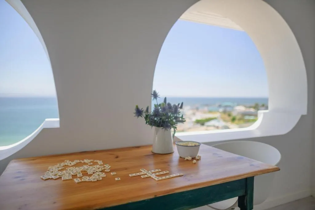 Ocean and coastline vista framed through large circular window opening