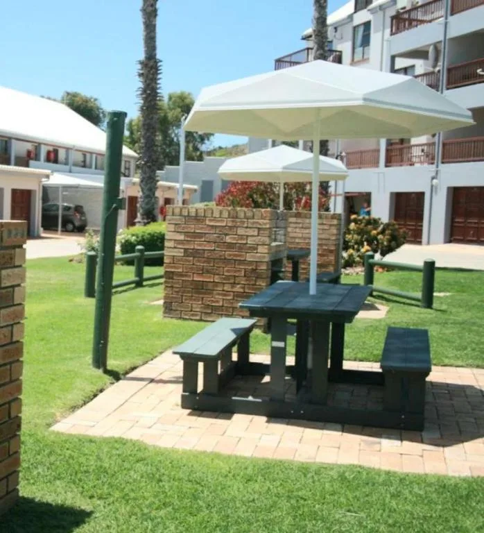 Outdoor patio with shaded seating area and manicured lawn