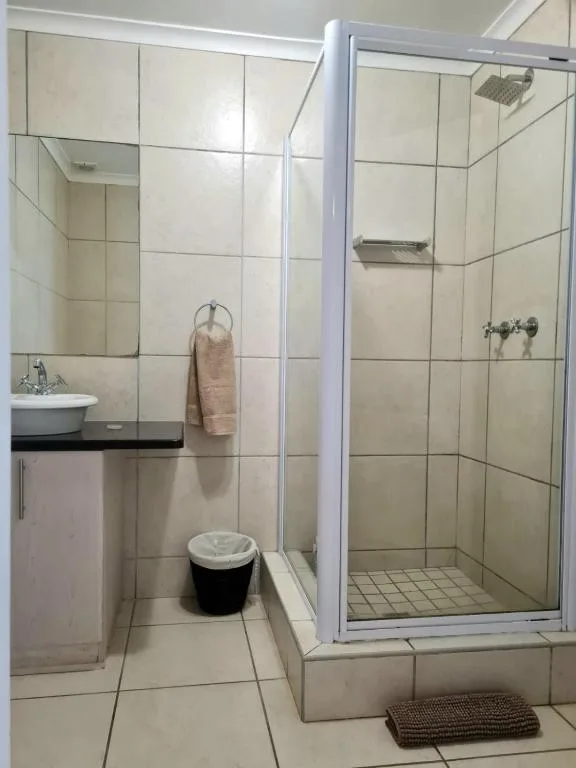 Modern bathroom with walk-in shower, vanity sink, and tiled floors
