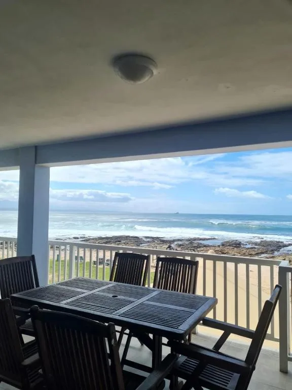 Elevated patio with dining table overlooking ocean and coastal landscape