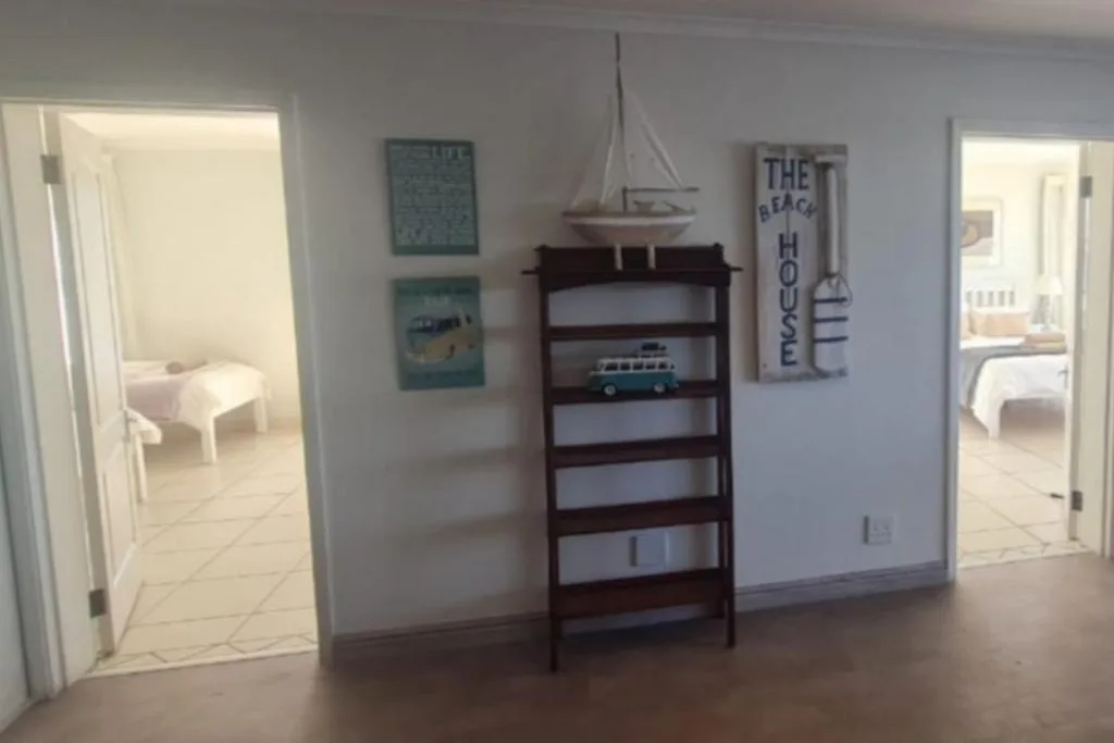 Bright open-plan living area with nautical decor and bedroom access
