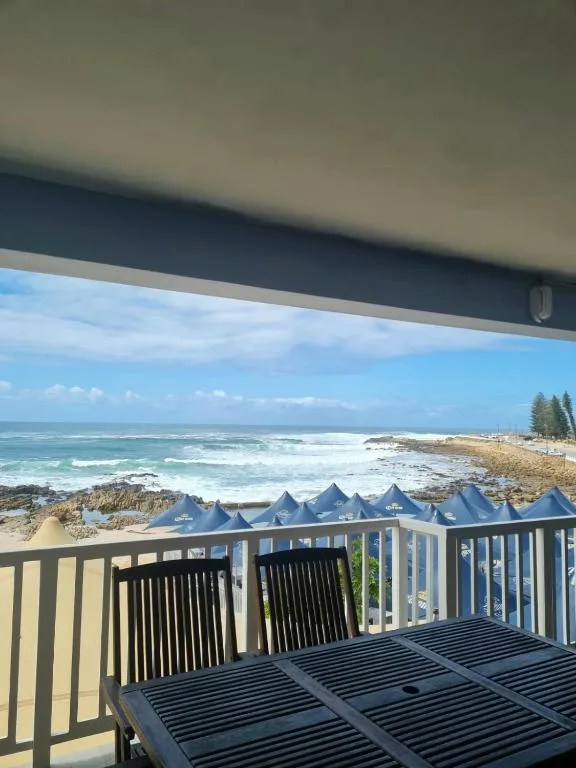 Oceanfront view with waves, beach, and coastal landscape from deck