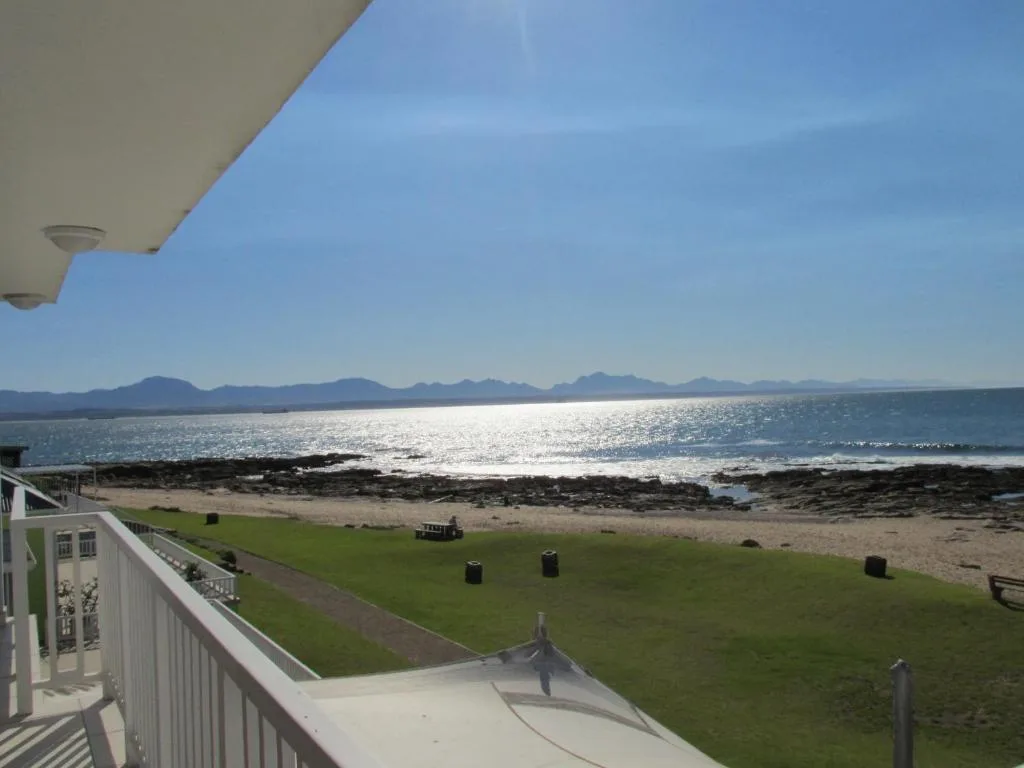 Ocean and mountain vista from beachfront property deck with lawn